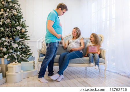 Beautiful pregnant woman sitting with doughter and husband 58762716