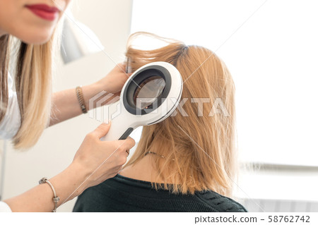 A trichologist examines the condition of the hair 58762742