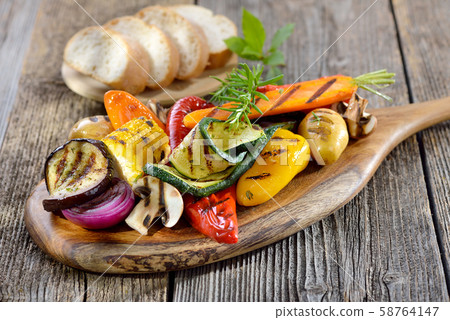Vegan cuisine: Mixed grilled vegetables on a wooden cutting board served with Italian ciabatta bread 58764147