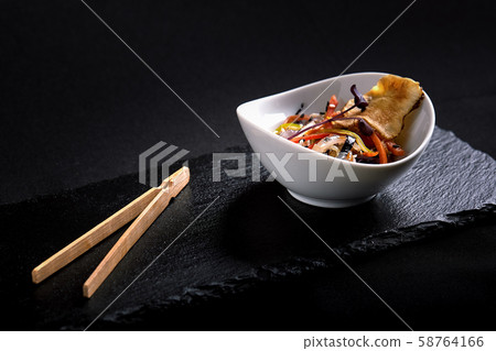 Asian with miso pasta, soy sauce, herbs. On a black stone table, with chopsticks. Copy top view 58764166