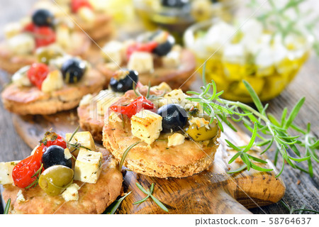 Warm Greek appetizers: Crispy baked pita bread with feta cheese, olives, peppers and herbs 58764637