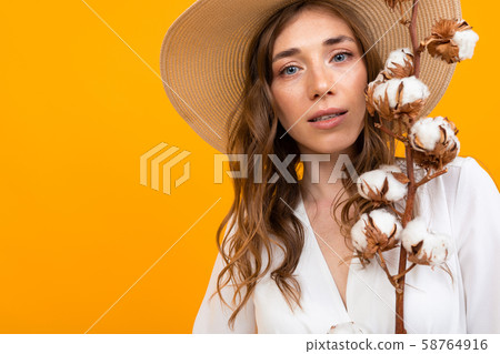 large portrait of a mysterious middle-aged girl in a hat on an orange background, gently holds large portrait of a mysterious middle-aged girl in a hat on an orange background, gently holds 58764916