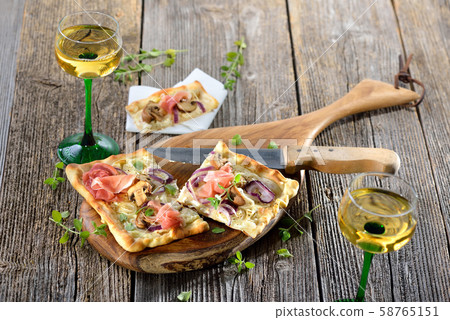 Tarte Flambee from Alsace with sour cream, onions, mushrooms and serrano ham, served with white wine 58765151
