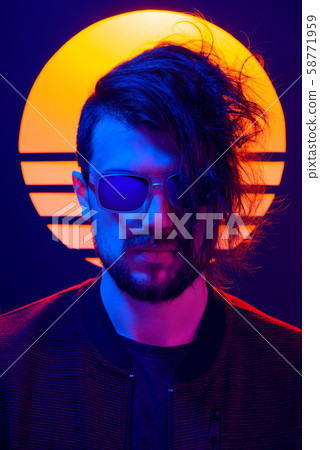 Retro wave synth wave portrait of a young man in sunglasses. 80s sci-fi futuristic fashion poster style violet neon with sun on background. 58771959