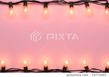 Light bulb string light. Retro garland edison warm lights on pink pastel background. 58772005