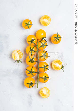 Yellow tomatoes, ripe cherry tomato on branch, on rustic table top view 58772123
