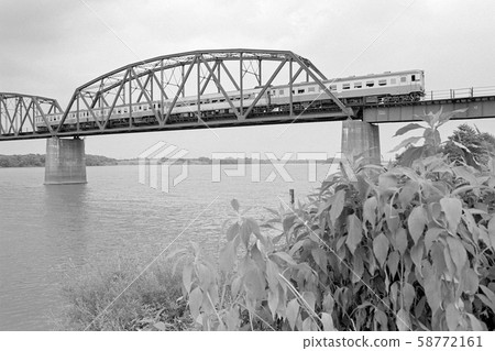 A diesel train that crosses the Ishikari River Bridge on the Sennuma Line 58772161