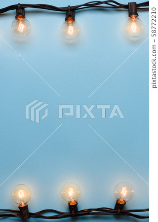 Light bulbs retro garland string lights on blue background Light bulbs retro garland string lights on blue background 58772210