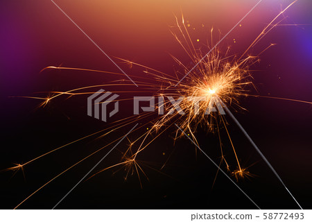 New year sparkler glittering candle magic festive light on dark background. Christmas party sparkler or Bengal fire. 58772493