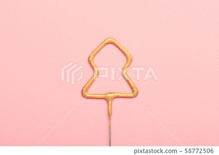 Golden sparkler in shape of christmas tree on pink background. New year concept. Golden sparkler in shape of christmas tree on pink background. New year concept. 58772506
