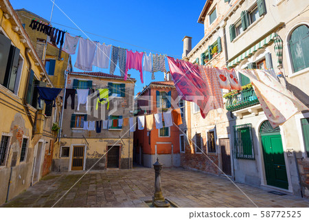 Venice Italy street with laundry washed clothes hanging out to dry on ropes Venice Italy street with laundry washed clothes hanging out to dry on ropes 58772525