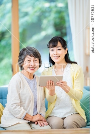 Parent and child who operate a tablet terminal Mother and child Senior female Middle female 2 persons 58775632
