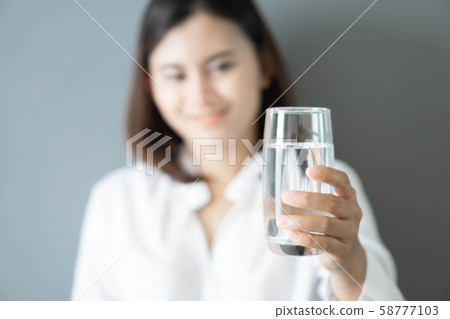 Close up woman hand holding glass of pure water 58777103