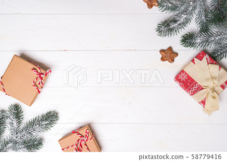 Gift boxes with snow spruce branches and stars cookies on a white wooden background. Christmas card Gift boxes with snow spruce branches and stars cookies on a white wooden background. Christmas card 58779416