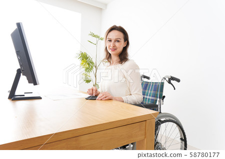 一個坐在輪椅上工作的外國女人 一個坐在輪椅上工作的外國女人 58780177