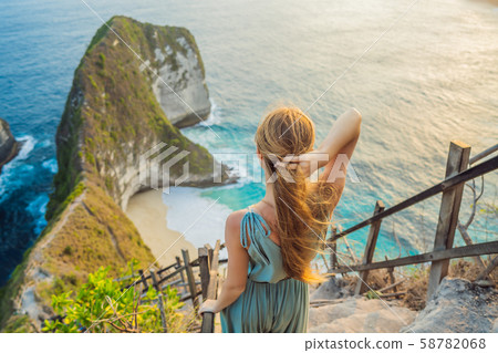 Family vacation lifestyle. Happy woman stand at viewpoint. Look at beautiful beach under high cliff Family vacation lifestyle. Happy woman stand at viewpoint. Look at beautiful beach under high cliff 58782068