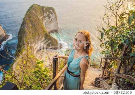 Family vacation lifestyle. Happy woman stand at viewpoint. Look at beautiful beach under high cliff 58782109