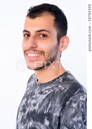 Closeup profile view of happy young bearded Persian man looking at camera 58784309