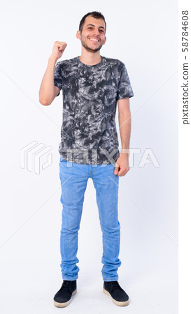 Full body shot of happy young bearded Persian man with fist raised Full body shot of happy young bearded Persian man with fist raised 58784608
