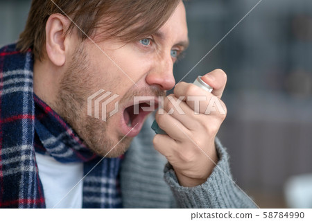 Blue-eyed man feeling terrible while having asthma attack Blue-eyed man feeling terrible while having asthma attack 58784990