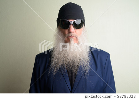 Face of mature bearded businessman in suit with sunglasses and beanie Face of mature bearded businessman in suit with sunglasses and beanie 58785328