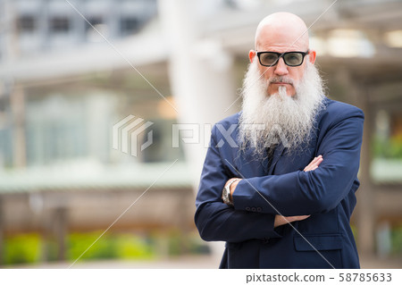 Mature bearded bald businessman with sunglasses in the city outdoors 58785633