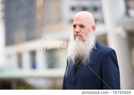 Mature bearded bald businessman thinking in the city outdoors 58785689