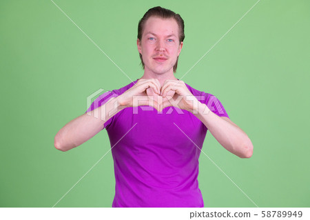 Portrait of young handsome man with hand heart gesture Portrait of young handsome man with hand heart gesture 58789949