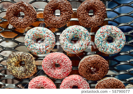 Multi-colored glazed donuts on a wire rack. Fast Food Concept, Delicious Dessert 58790077
