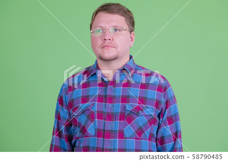 Overweight bearded hipster man with eyeglasses thinking 58790485