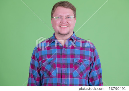 Happy overweight bearded hipster man with eyeglasses smiling 58790491