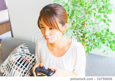 A scene where a housewife enjoys a game for a change of character A person model A female game controller Living 58790606