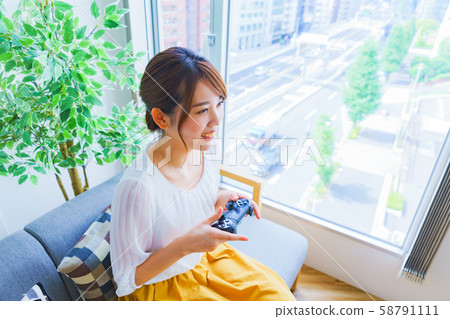 A woman enjoying a game at a home party Japanese lifestyle living salon matching room 58791111