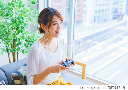A young wife changes her mood with a game. Japanese, lifestyle, housewife, own pace, home, freedom. A young wife changes her mood with a game. Japanese, lifestyle, housewife, own pace, home, freedom. 58791249