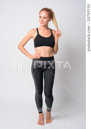 Full body shot of young blonde woman thinking ready for gym Full body shot of young blonde woman thinking ready for gym 58793550
