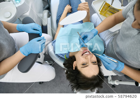 Pretty woman's teeth treatment in dental clinic 58794620