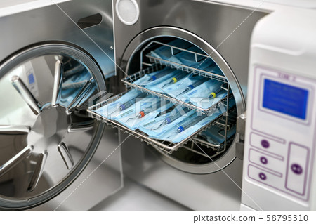 Sterilize machine with opened door and dental probes inside 58795310