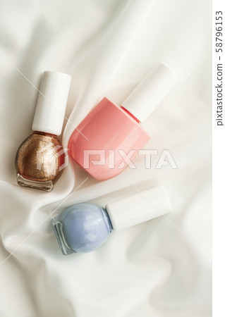 Nail polish bottles on silk background, french 58796153