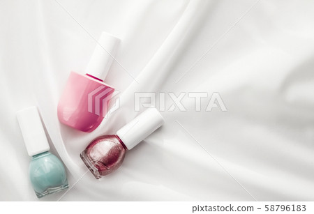 Nail polish bottles on silk background, french Nail polish bottles on silk background, french 58796183