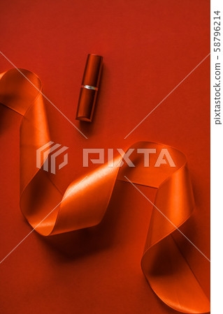 Luxury lipstick and silk ribbon on orange holiday 58796214
