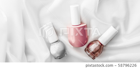 Nail polish bottles on silk background, french 58796226