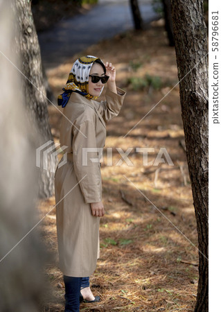 Woman running away in trench coat 58796681