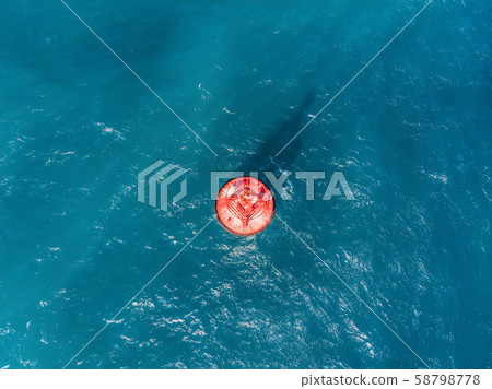 Floating red navigational buoy on blue sea, gulf. Drone 58798778