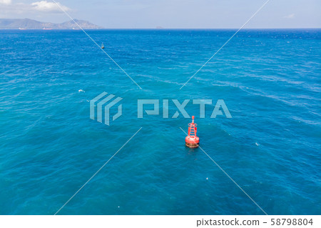 Floating red navigational buoy on blue sea, gulf. Drone 58798804