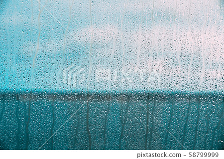 Drops Of Water Or Rain On Wet Glass Background. Moody Photo In Cold Blue Color Drops Of Water Or Rain On Wet Glass Background. Moody Photo In Cold Blue Color 58799999