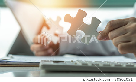 Business solution and strategy for corporate business success concept with jigsaw puzzle pieces in businessman hands finding problem solving idea and strategic planning 58801051