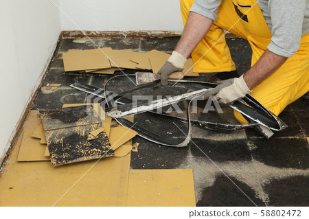 Old vinyl tiles removal from floor in a room or 58802472