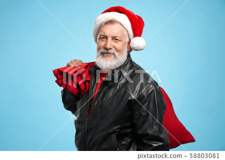 Elder bearded man in Santa Claus hat with christmas presents 58803081