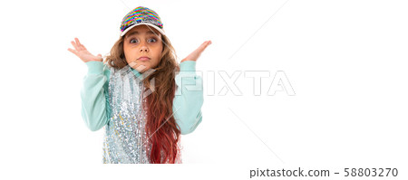 Teenage girl with long blonde hair dyed with tips pink, in shiny white cap, light blue sports suit 58803270