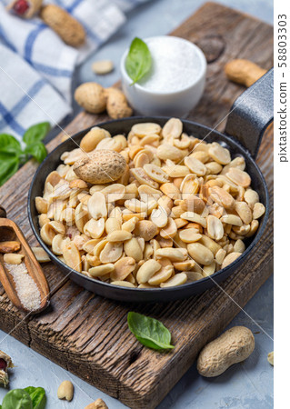 Metal pan with salted peanuts. 58803303